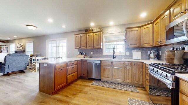 1313 W Ridge Ln, Champaign, IL 61822 - kitchen featuring appliances with stainless steel finishes, a peninsula, light countertops, light wood-type flooring, and recessed lighting
