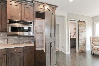26205 W Forrester Dr, Plainfield, IL 60585 - kitchen featuring oven, a barn door, light countertops, tasteful backsplash, and dark wood-style flooring