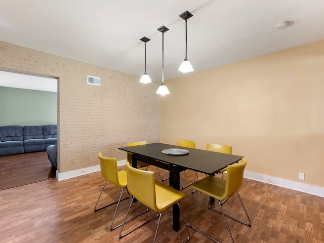 225 S Gladstone Ave, Aurora, IL 60506 - dining space featuring wood finished floors, brick wall, and baseboards