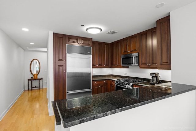 60 E Monroe St Unit 1604, Chicago, IL 60603 - kitchen with appliances with stainless steel finishes, a peninsula, light wood-type flooring, dark stone countertops, and recessed lighting