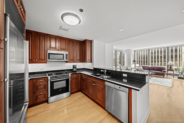 60 E Monroe St Unit 1604, Chicago, IL 60603 - kitchen with stainless steel appliances, a sink, light wood finished floors, a peninsula, and open floor plan