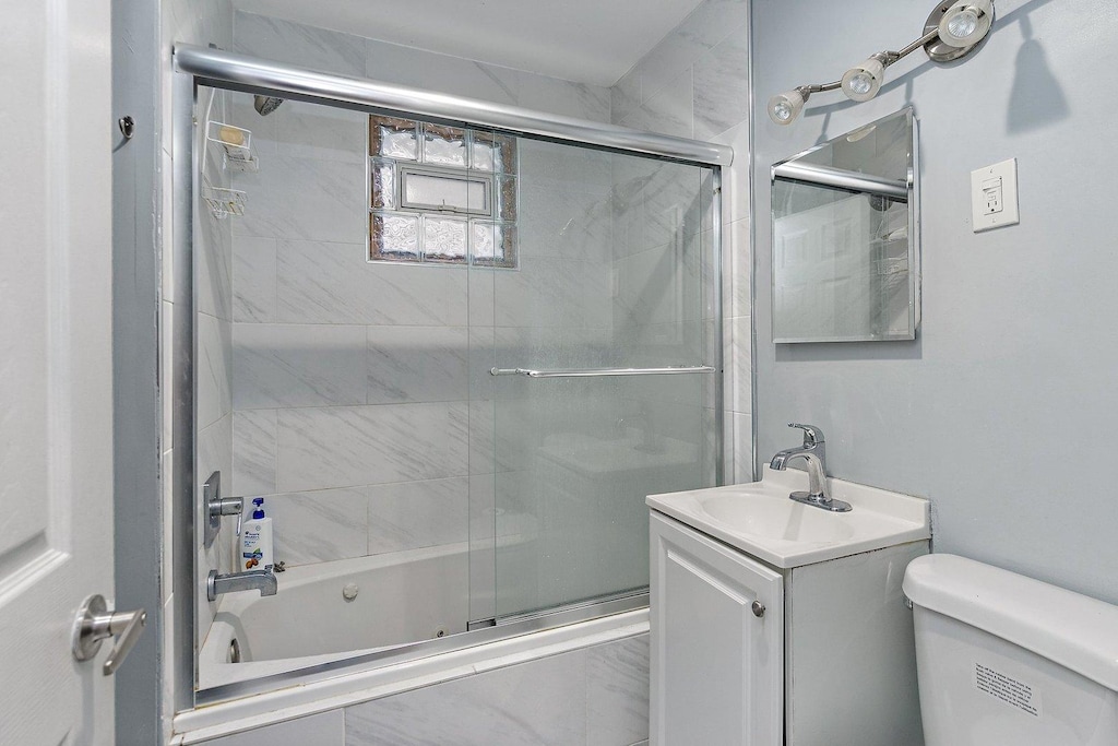 2214 N Mango Ave, Chicago, IL 60639 - bathroom with enclosed tub / shower combo, toilet, and vanity