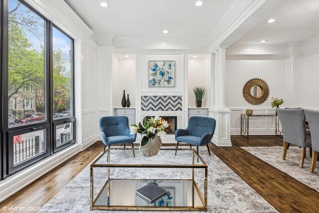 1717 W Huron St, Chicago, IL 60622 - living area with decorative columns, a decorative wall, wood finished floors, crown molding, and a fireplace