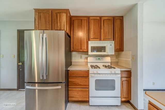 337 George St, Sycamore, IL 60178 - kitchen featuring white appliances, brown cabinetry, decorative backsplash, and light countertops