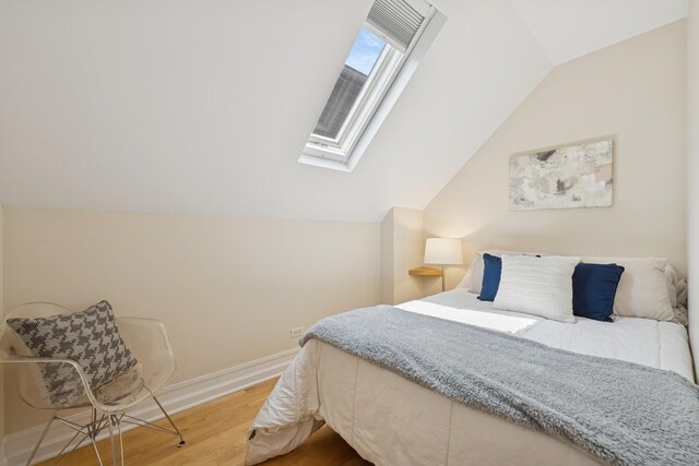 1325 W Wolfram St Unit 3, Chicago, IL 60657 - bedroom with wood finished floors, a skylight, lofted ceiling, and baseboards