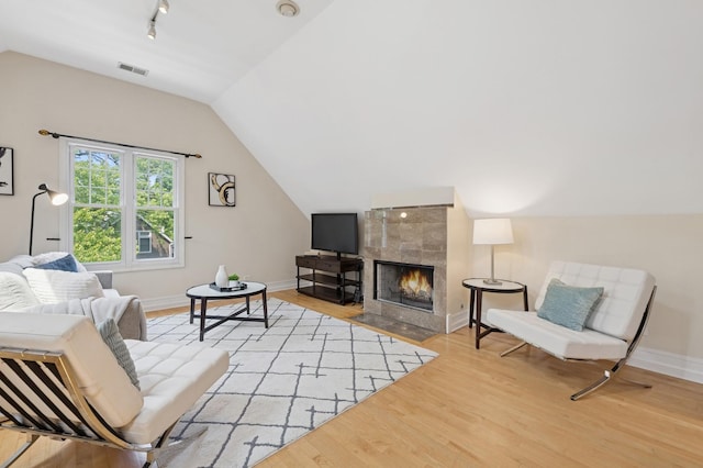 1325 W Wolfram St Unit 3, Chicago, IL 60657 - living area featuring lofted ceiling, wood finished floors, baseboards, a tile fireplace, and track lighting