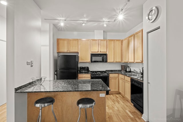 333 N Jefferson St Unit 307, Chicago, IL 60661 - kitchen featuring black appliances, light brown cabinets, light wood-type flooring, and a kitchen bar