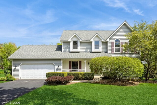 321 Greens View Dr, Algonquin, IL 60102 - traditional-style house featuring an attached garage, driveway, covered porch, and roof with shingles