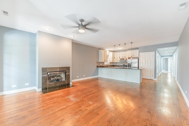 4011 W Fullerton Ave Unit 2E, Chicago, IL 60639 - unfurnished living room with a ceiling fan, baseboards, and light wood-style floors