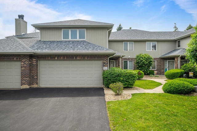 8964 Dublin St Unit 12C, Orland Park, IL 60462 - view of front facade with asphalt driveway, a chimney, a front yard, brick siding, and roof with shingles