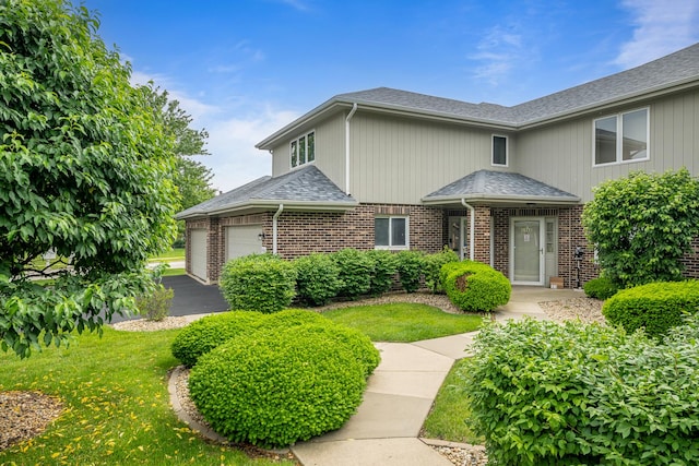 8964 Dublin St Unit 12C, Orland Park, IL 60462 - view of front of house with brick siding, roof with shingles, an attached garage, and a front yard