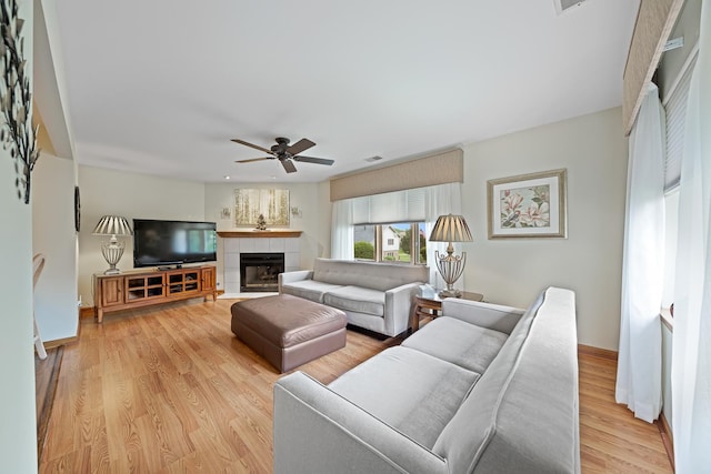 8964 Dublin St Unit 12C, Orland Park, IL 60462 - living room featuring ceiling fan, light wood finished floors, a tiled fireplace, and baseboards