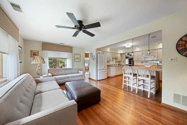 8964 Dublin St Unit 12C, Orland Park, IL 60462 - living area featuring light wood finished floors, a ceiling fan, and baseboards