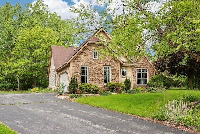 N61W14730 Woodcrest Ct, Menomonee Falls, WI 53051 - view of front facade with brick siding, driveway, an attached garage, and a front yard