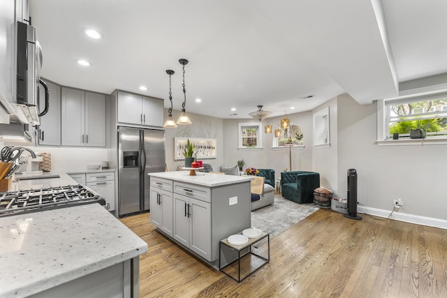 4717 N Kenmore Ave Unit Gs, Chicago, IL 60640 - kitchen with stainless steel appliances, gray cabinets, light wood finished floors, recessed lighting, and hanging light fixtures