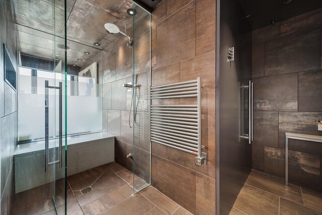 1530 S State St Unit 18A-B, Chicago, IL 60605 - bathroom with radiator, a towel warmer, a shower stall, tile patterned floors, and tile walls
