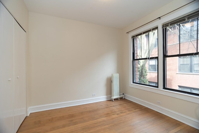 7631 N Eastlake Ter Unit 2C, Chicago, IL 60626 - spare room featuring radiator heating unit, light wood-style flooring, and baseboards