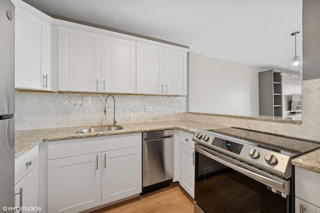 2020 N Lincoln Park W Unit 30L, Chicago, IL 60614 - kitchen with stainless steel appliances, a sink, decorative backsplash, white cabinetry, and light stone counters
