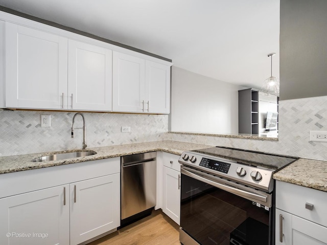 2020 N Lincoln Park W Unit 30L, Chicago, IL 60614 - kitchen featuring appliances with stainless steel finishes, a sink, tasteful backsplash, white cabinets, and light wood-style flooring