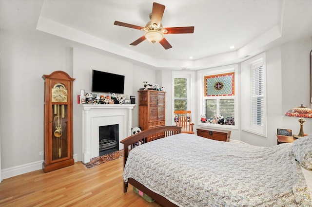 1705 N Crilly Ct Unit 2, Chicago, IL 60614 - bedroom featuring a tray ceiling, light wood-style flooring, a fireplace with flush hearth, recessed lighting, and a ceiling fan