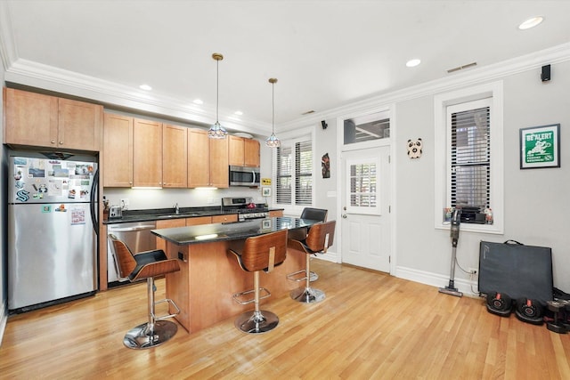 1705 N Crilly Ct Unit 2, Chicago, IL 60614 - kitchen with stainless steel appliances, light wood-style flooring, a kitchen bar, dark countertops, and a kitchen island