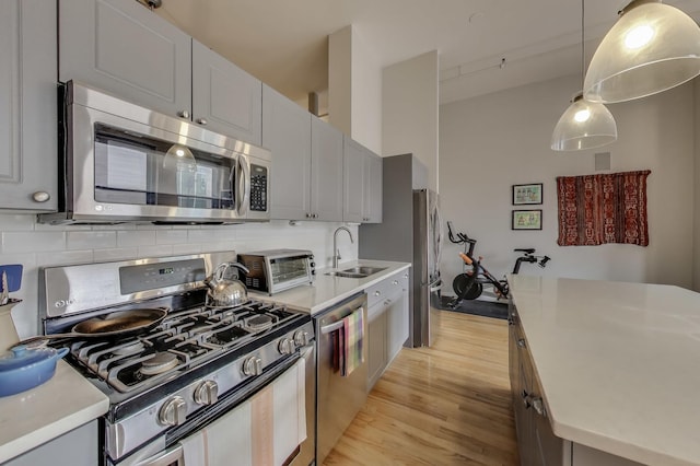 3151 N Lincoln Ave Unit 204, Chicago, IL 60657 - kitchen featuring appliances with stainless steel finishes, a sink, light wood finished floors, tasteful backsplash, and light countertops