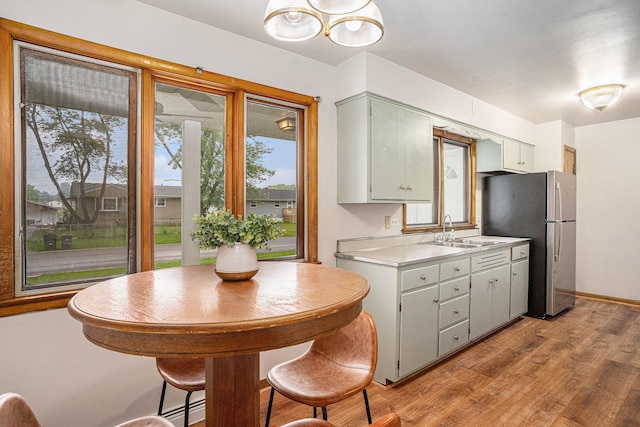 2258 177th St, Lansing, IL 60438 - kitchen featuring a sink, freestanding refrigerator, light countertops, light wood-type flooring, and a chandelier