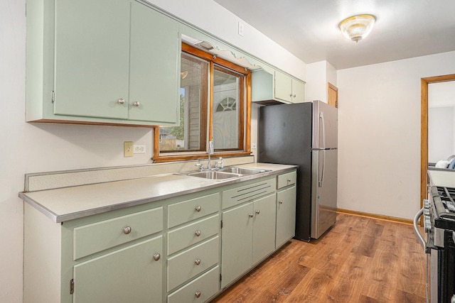 2258 177th St, Lansing, IL 60438 - kitchen with a sink, green cabinetry, stainless steel appliances, light wood-style floors, and light countertops