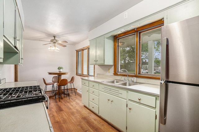 2258 177th St, Lansing, IL 60438 - kitchen featuring appliances with stainless steel finishes, a sink, light countertops, light wood-type flooring, and a ceiling fan