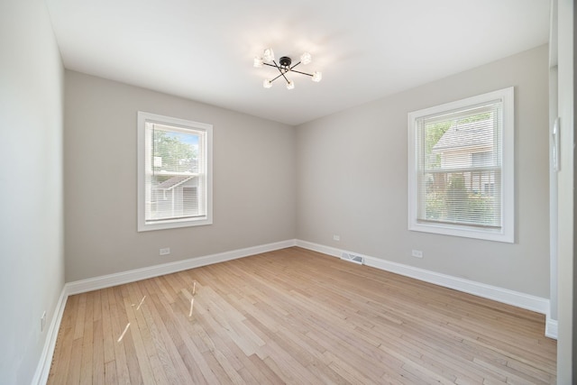 791 N Michigan St, Elmhurst, IL 60126 - empty room with light wood-type flooring, baseboards, and a chandelier