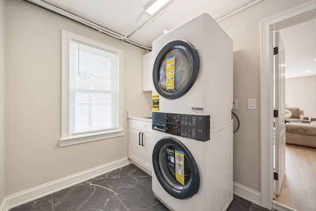 791 N Michigan St, Elmhurst, IL 60126 - washroom featuring stacked washer and clothes dryer, cabinet space, baseboards, and dark marble finish floors