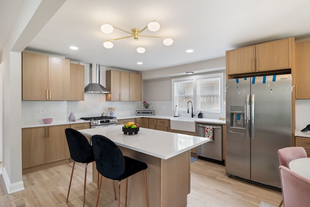 791 N Michigan St, Elmhurst, IL 60126 - kitchen featuring appliances with stainless steel finishes, a sink, wall chimney range hood, light wood-style floors, and a kitchen breakfast bar