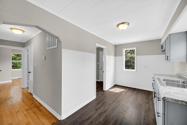 20801 Western Ave, Chicago Heights, IL 60411 - kitchen with wood-type flooring, gray cabinetry, light countertops, a wainscoted wall, and ornamental molding