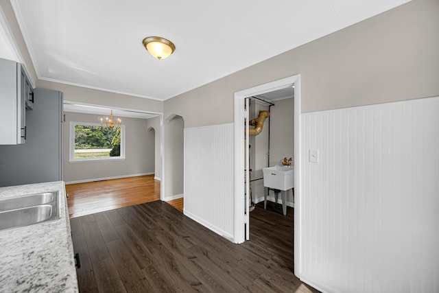 20801 Western Ave, Chicago Heights, IL 60411 - unfurnished dining area with dark wood-style floors, a chandelier, arched walkways, and a wainscoted wall