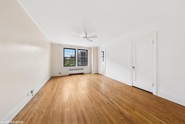 6901 S Oglesby Ave Unit 2A, Chicago, IL 60649 - spare room featuring radiator heating unit, ceiling fan, light wood-type flooring, and baseboards