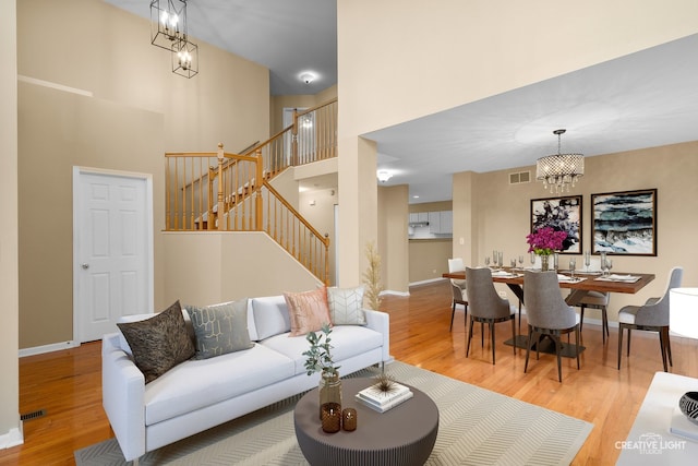 2539 Lexington Ln, Naperville, IL 60540 - living room featuring a chandelier, stairway, wood finished floors, a high ceiling, and baseboards