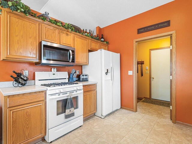 4306 Westridge Dr, Winnebago, IL 61088 - kitchen featuring white appliances, light countertops, and brown cabinetry