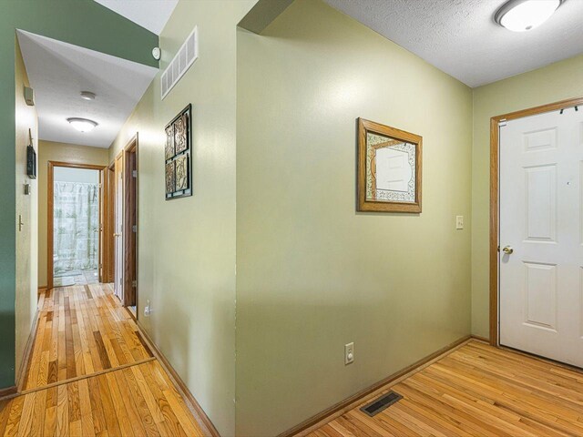 4306 Westridge Dr, Winnebago, IL 61088 - hall with light wood-style floors, baseboards, and a textured ceiling