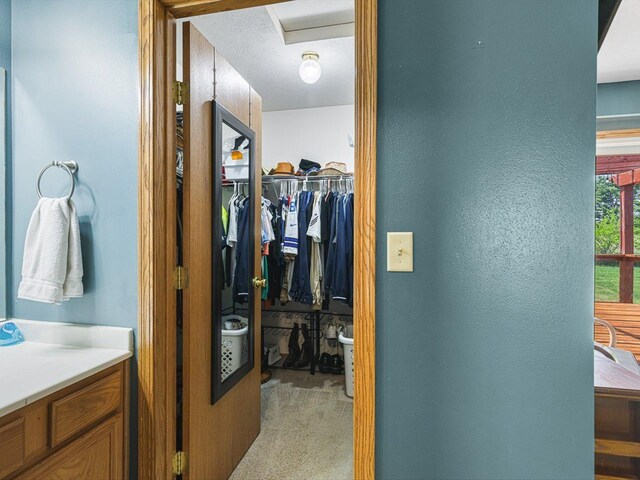 4306 Westridge Dr, Winnebago, IL 61088 - hallway featuring light colored carpet, a textured wall, and attic access