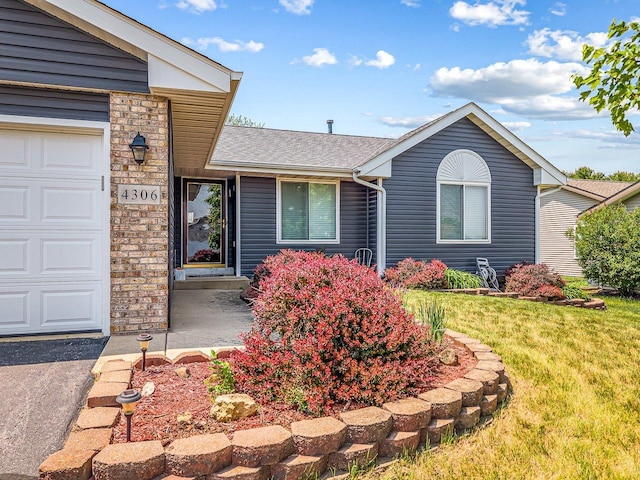 4306 Westridge Dr, Winnebago, IL 61088 - ranch-style house with a front lawn, stone siding, and roof with shingles