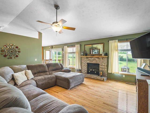 4306 Westridge Dr, Winnebago, IL 61088 - living room featuring a textured ceiling, a ceiling fan, wood finished floors, and a brick fireplace