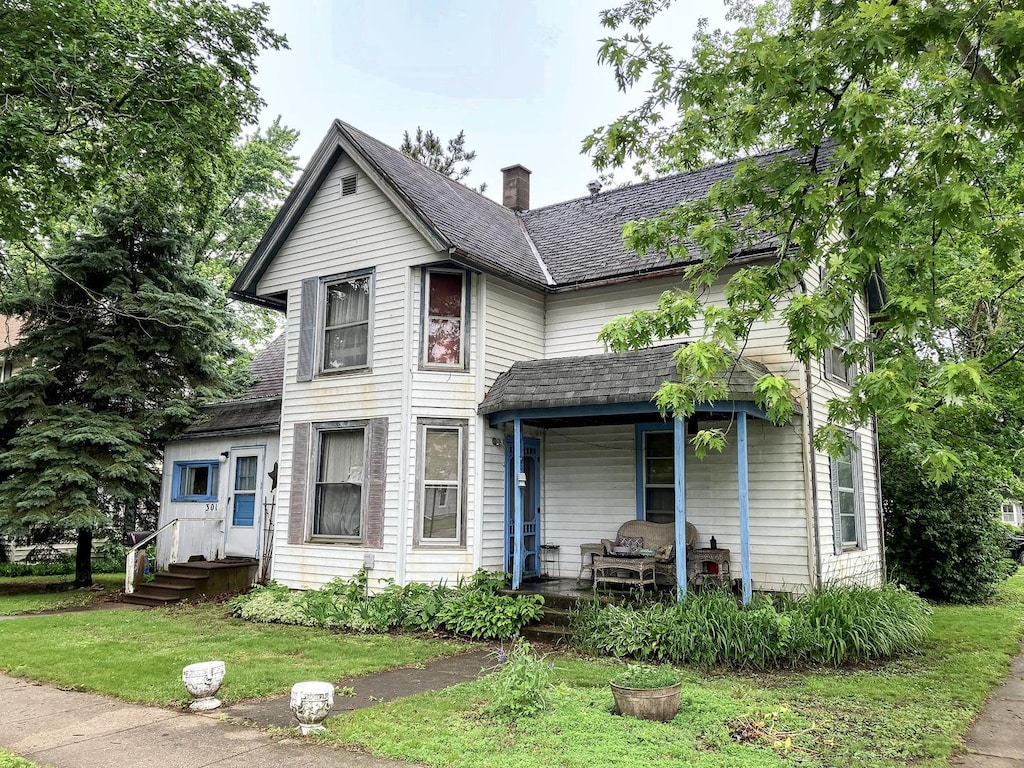 301 S Grape St, Morrison, IL 61270 - victorian home featuring covered porch, a chimney, and a front lawn