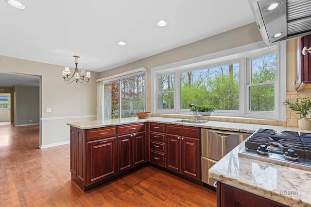 43 Kings Cross Dr, Lincolnshire, IL 60069 - kitchen featuring a sink, light stone countertops, range hood, stainless steel gas cooktop, and recessed lighting