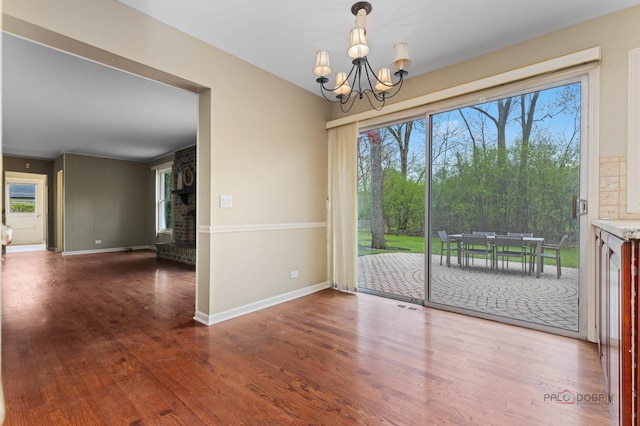 43 Kings Cross Dr, Lincolnshire, IL 60069 - unfurnished dining area featuring wood finished floors, a chandelier, baseboards, and healthy amount of natural light