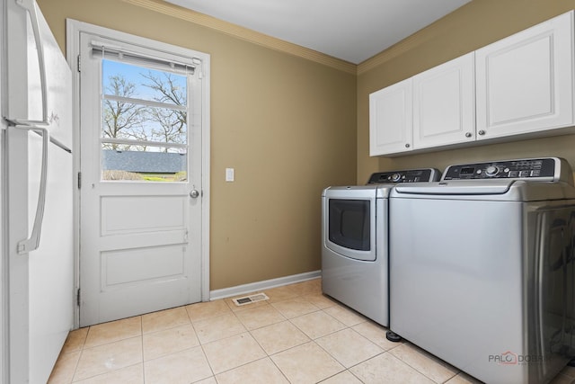 43 Kings Cross Dr, Lincolnshire, IL 60069 - laundry area with cabinet space, washing machine and clothes dryer, ornamental molding, baseboards, and light tile patterned flooring