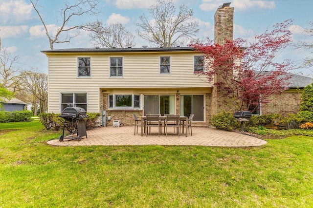 43 Kings Cross Dr, Lincolnshire, IL 60069 - back of property with a patio area, a lawn, a chimney, and brick siding