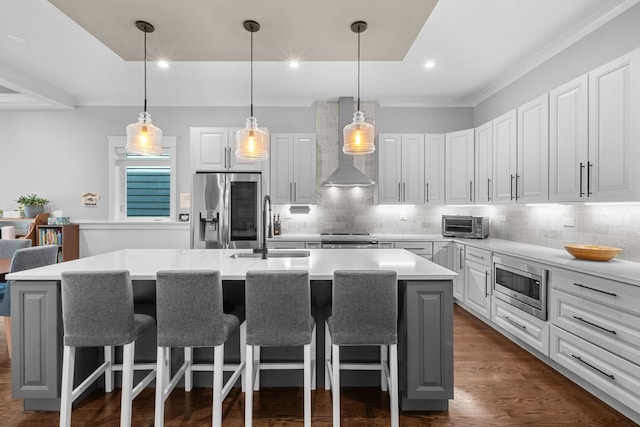 6336 S Kimbark Ave, Chicago, IL 60637 - kitchen featuring appliances with stainless steel finishes, wall chimney exhaust hood, a kitchen island with sink, light countertops, and decorative backsplash