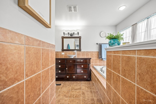 24147 S Sunset Dr, Channahon, IL 60410 - bathroom with vanity, a garden tub, tile patterned flooring, tile walls, and wainscoting
