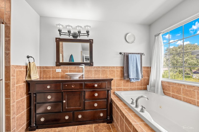 24147 S Sunset Dr, Channahon, IL 60410 - bathroom featuring a tub with jets, vanity, tile walls, tile patterned flooring, and a wainscoted wall