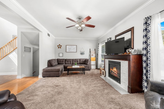 24147 S Sunset Dr, Channahon, IL 60410 - living area featuring ornamental molding, a ceiling fan, stairway, a fireplace with flush hearth, and wood finished floors